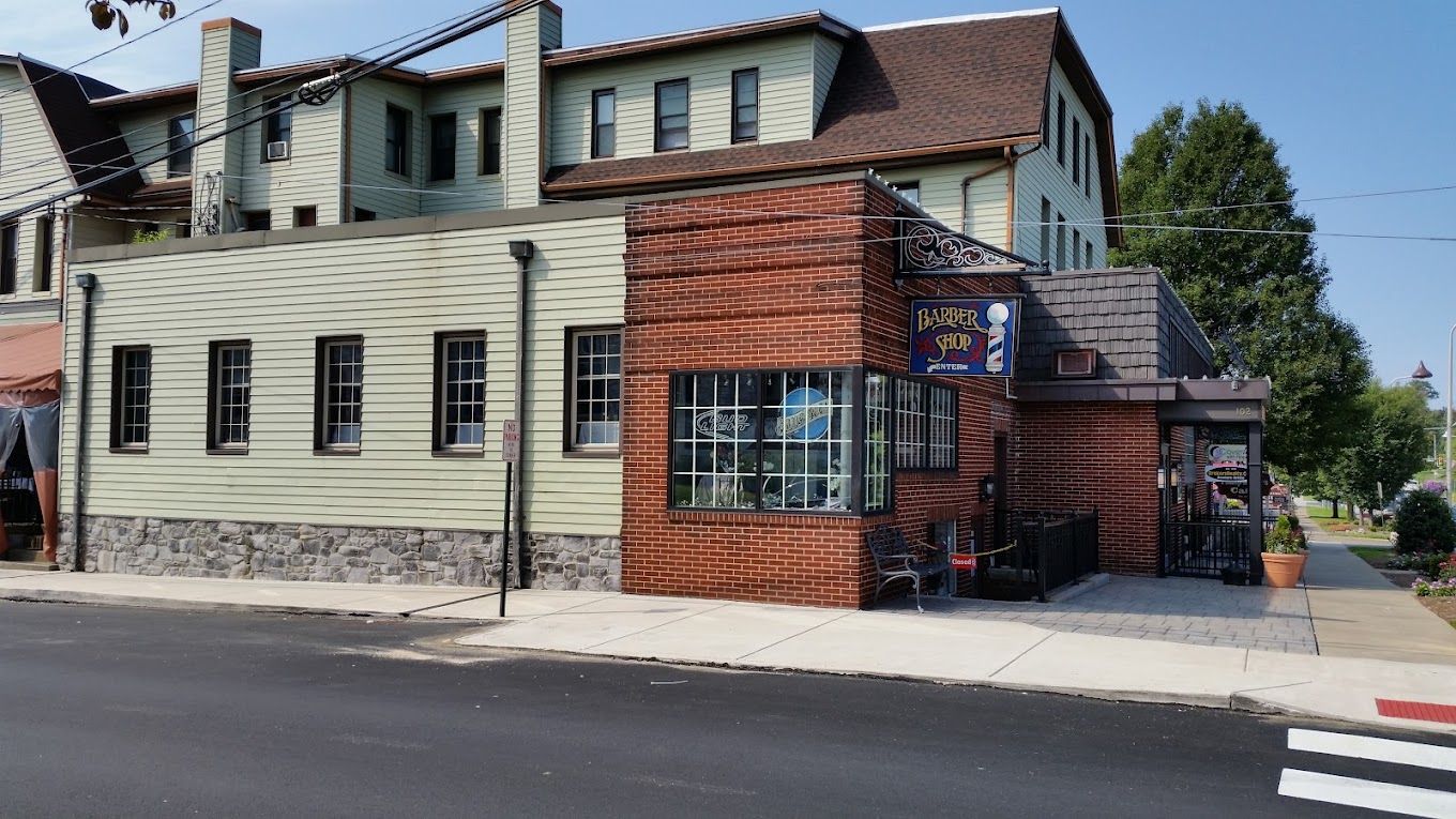 The shop's brick corner on West Chocolate Avenue, with the hanging Barber Shop sign