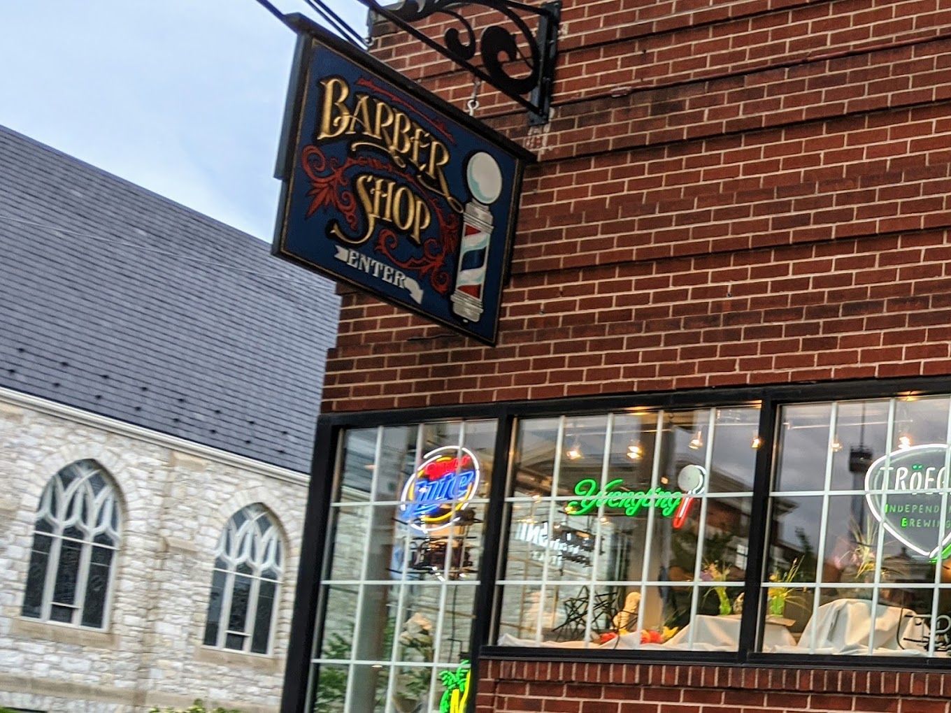 Painted Barber Shop sign with an arrow pointing to the entrance