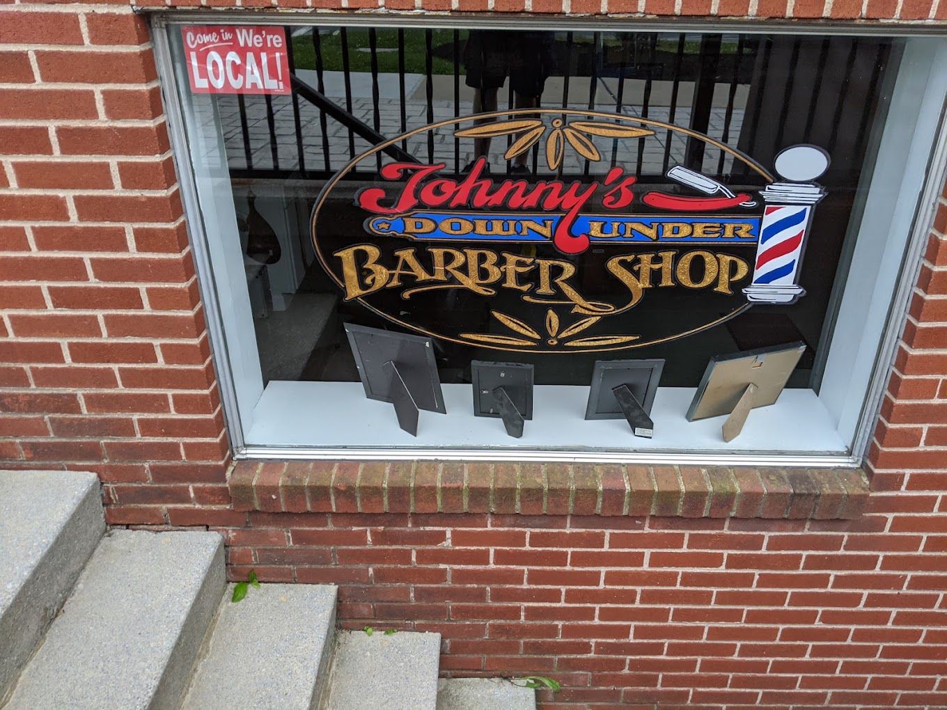 Hand-lettered Johnny's Down Under Barber Shop window beside the steps